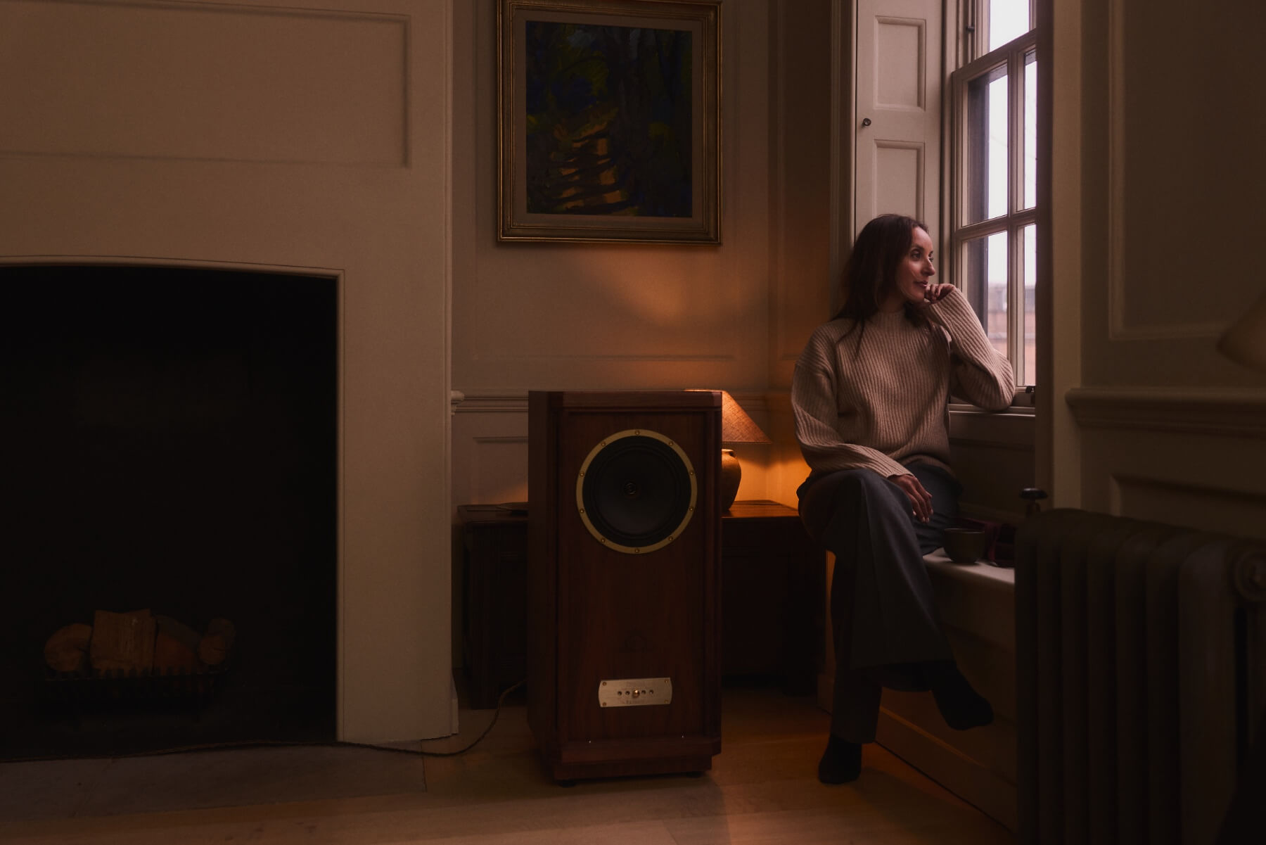 Asha Chong, acupunturist sitting by the window, looking outside and in thought.